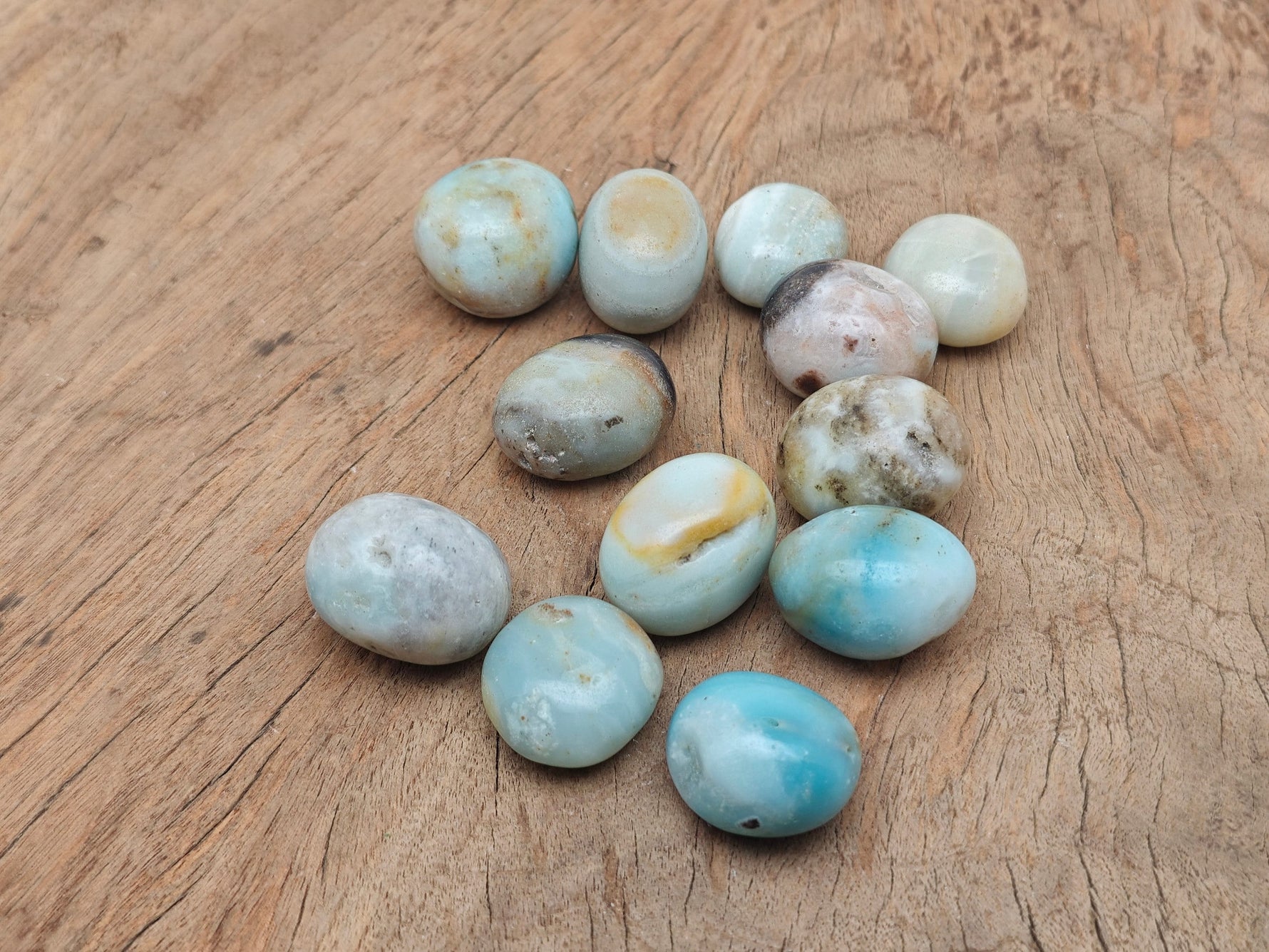 Caribbean Calcite tumbled stone from GemstoneGO showing smooth, colorful polished gemstone with vibrant orange and turquoise hues.