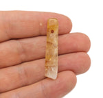 Citrine drilled tumbled gemstone pendant from GemstoneGO featuring a polished, vibrant yellow-orange citrine stone on a silver setting.
