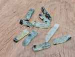 Prehnite drilled tumbled gemstone pendant from GemstoneGO, showing smooth green stone with drilled hole for necklace attachment.