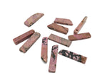 Rhodonite drilled tumbled gemstone pendant from GemstoneGO, showcasing a smooth pink and black patterned stone with a drilled hole for jewelry.
