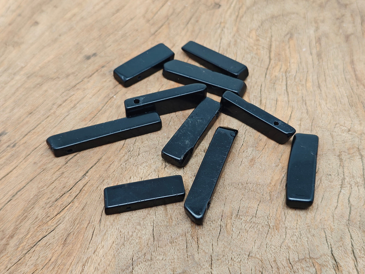 Obsidian drilled tumbled gemstone pendant from GemstoneGO featuring a smooth, polished black stone with a hole for jewelry.