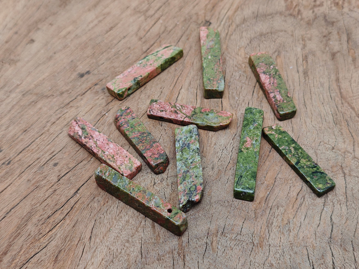 Unakite drilled tumbled gemstone pendant from GemstoneGO showcasing its vibrant green and pink natural stone pattern.