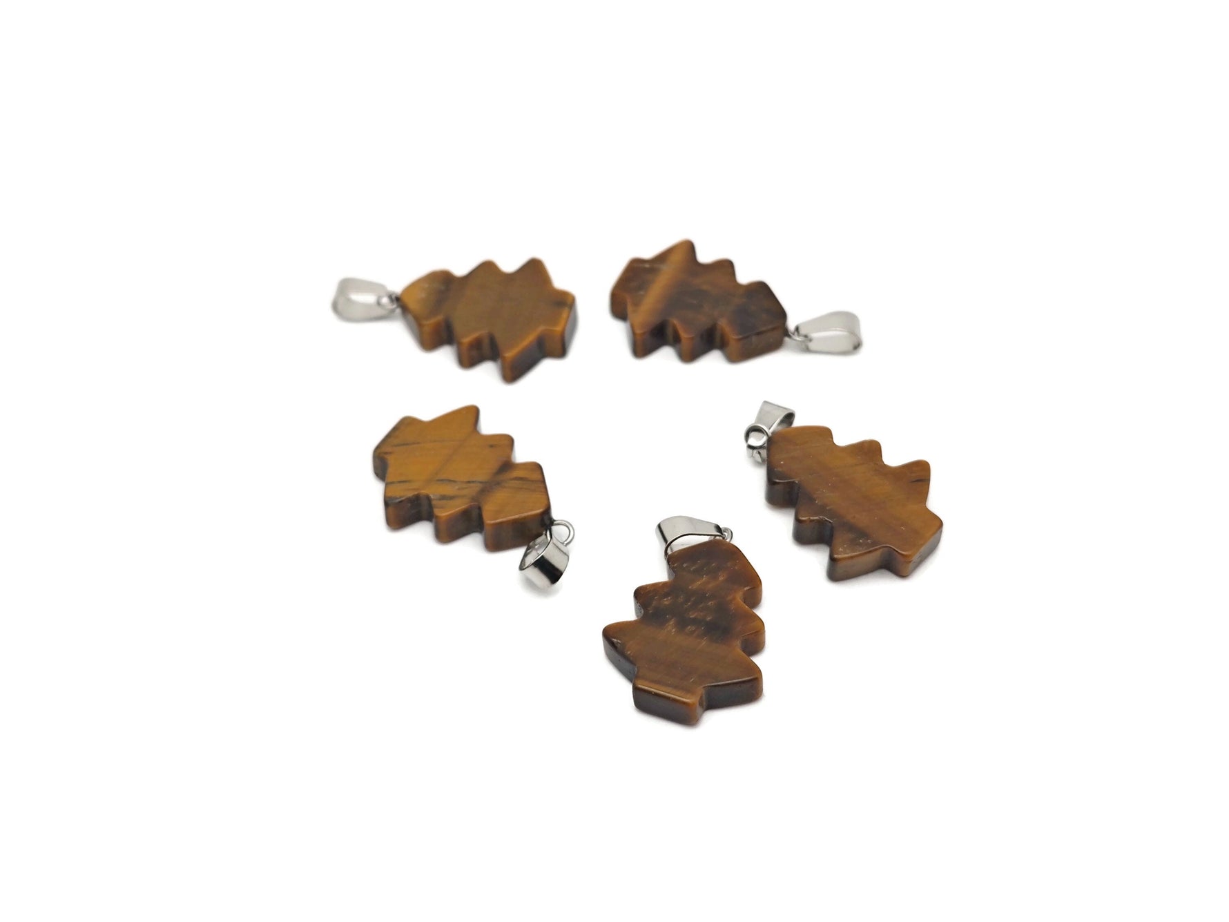 Tiger Eye gemstone pendant featuring a miniature pine tree design, showcasing warm brown and gold tones in a jewelry piece.