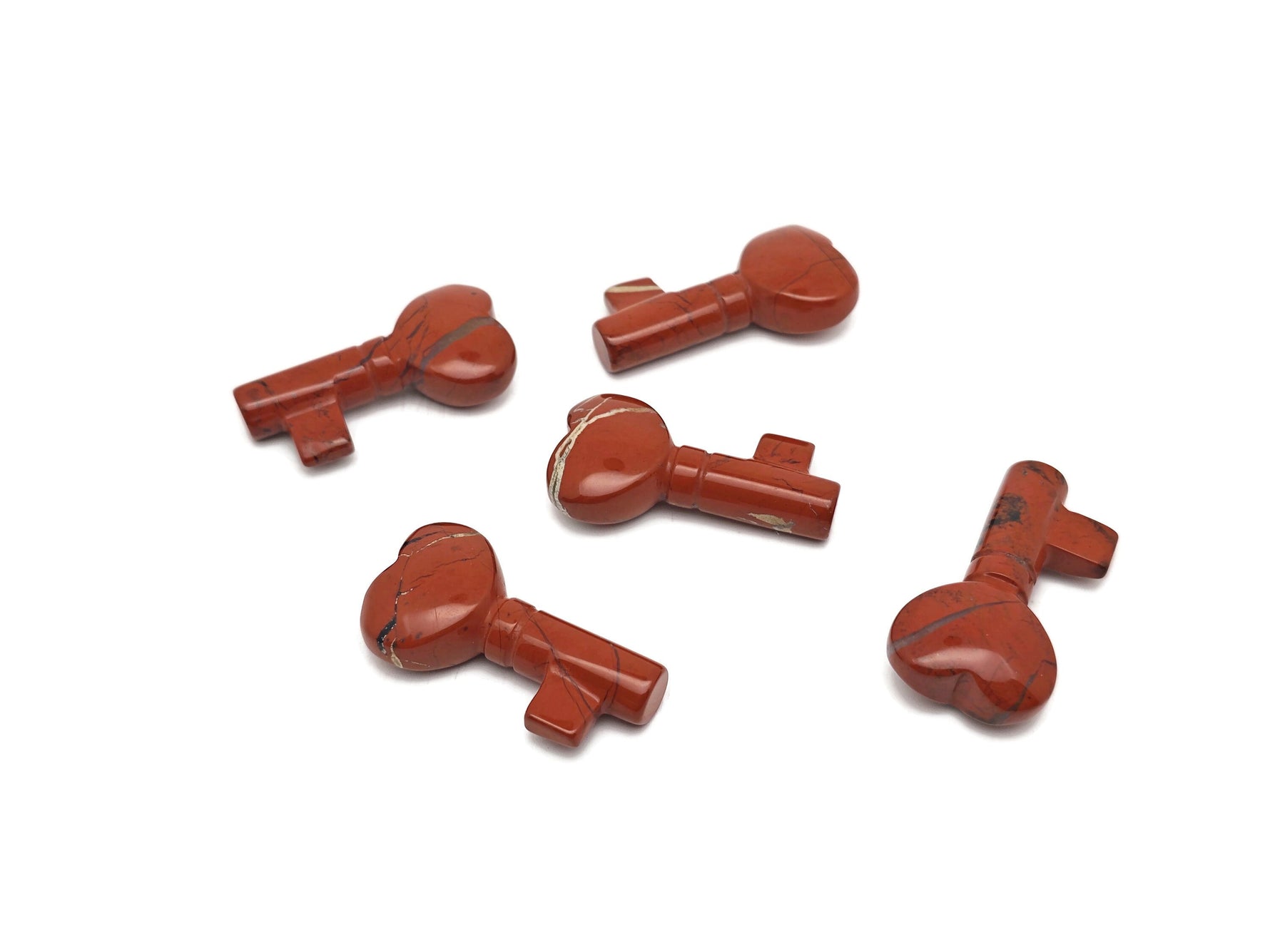 Red Jasper gemstone carving key, 40mm, from GemstoneGO, showcasing detailed craftsmanship and vibrant red color.