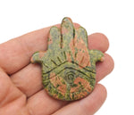 Unakite evil eye hand gemstone carving by GemstoneGO showing detailed carved stone with vibrant green and pink hues.