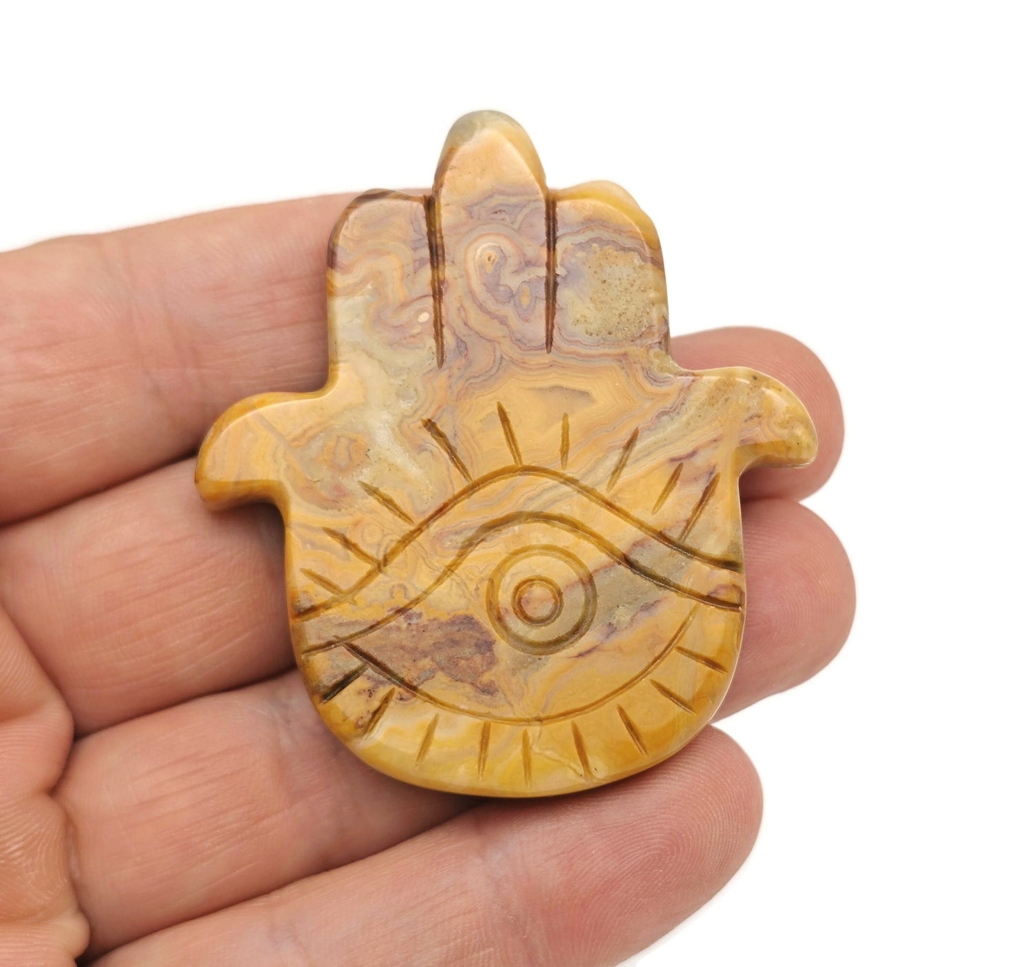 Crazy Lace Agate evil eye hand gemstone carving by GemstoneGO showing intricate details and vibrant colors on a polished stone