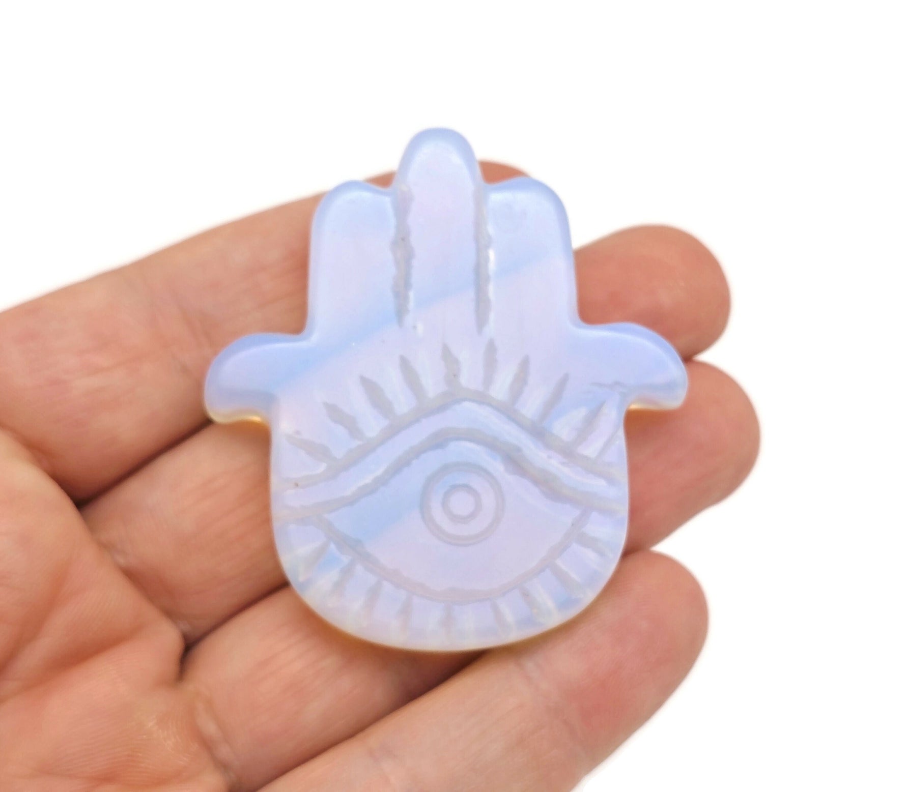 Opalite evil eye hand gemstone carving from GemstoneGO, detailed carved gemstone with protective evil eye design.