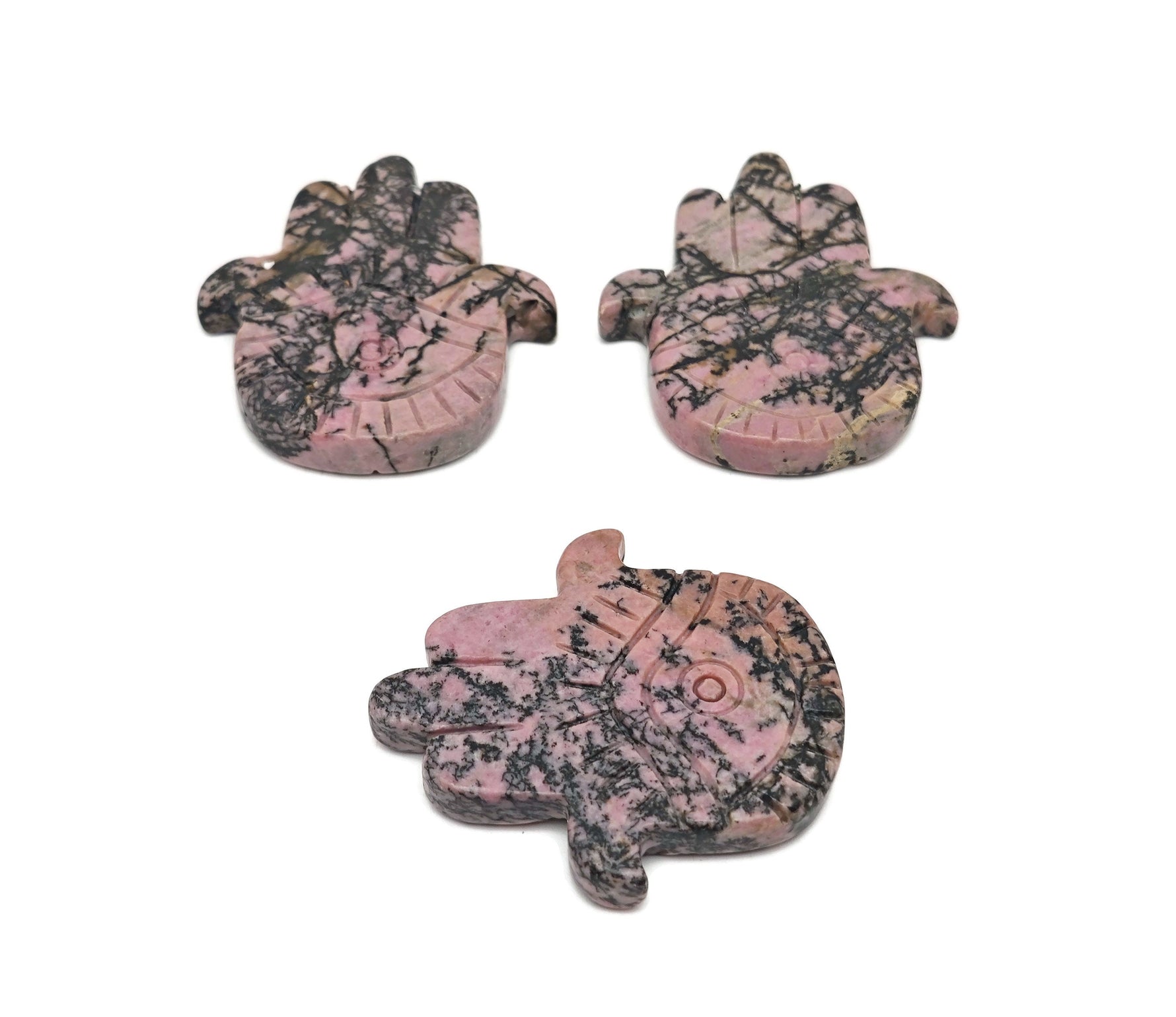 Rhodonite Evil Eye hand-carved gemstone talisman with intricate details, showcasing vibrant pink and black stone craftsmanship.