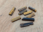 Tiger Eye drilled tumbled gemstone pendant from GemstoneGO, showcasing a smooth, polished oval with natural golden-brown hues.