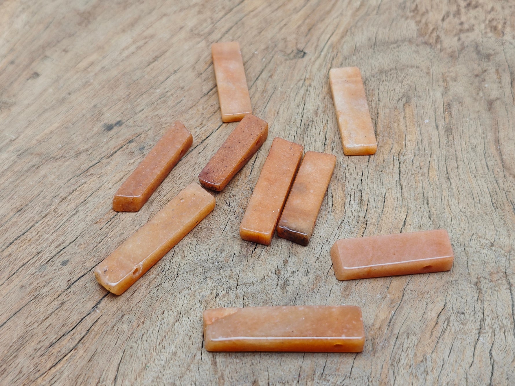 Orange aventurine drilled tumbled gemstone pendant from GemstoneGO, showcasing a smooth, polished orange gemstone with drilled hole for jewelry.