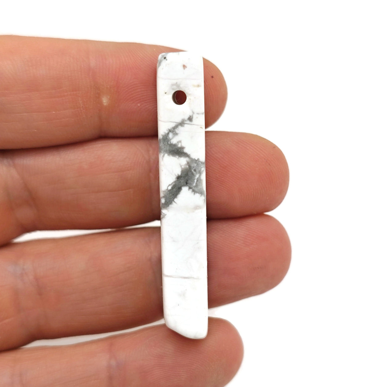 Howlite drilled tumbled gemstone pendant from GemstoneGO, showcasing a smooth, polished white stone with natural gray veins.