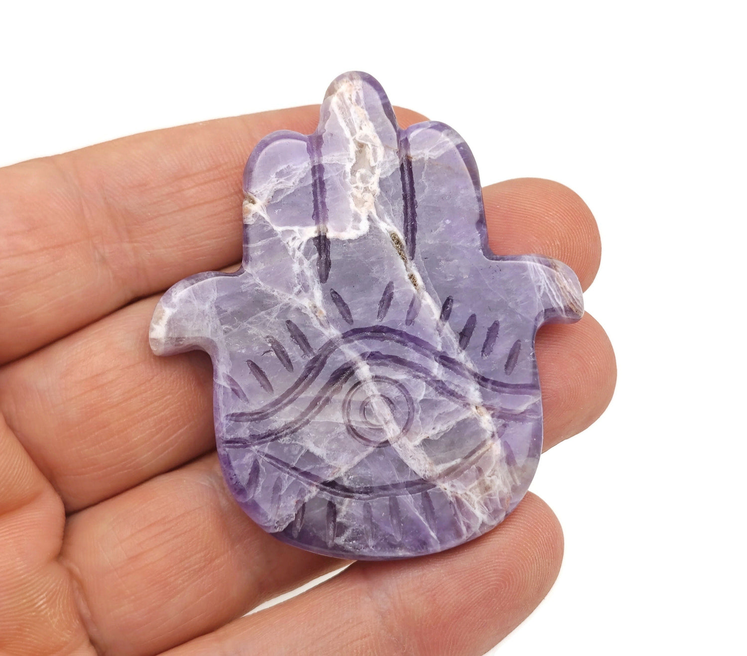 Amethyst evil eye hand gemstone carving by GemstoneGO, detailed purple amethyst with protective evil eye design.