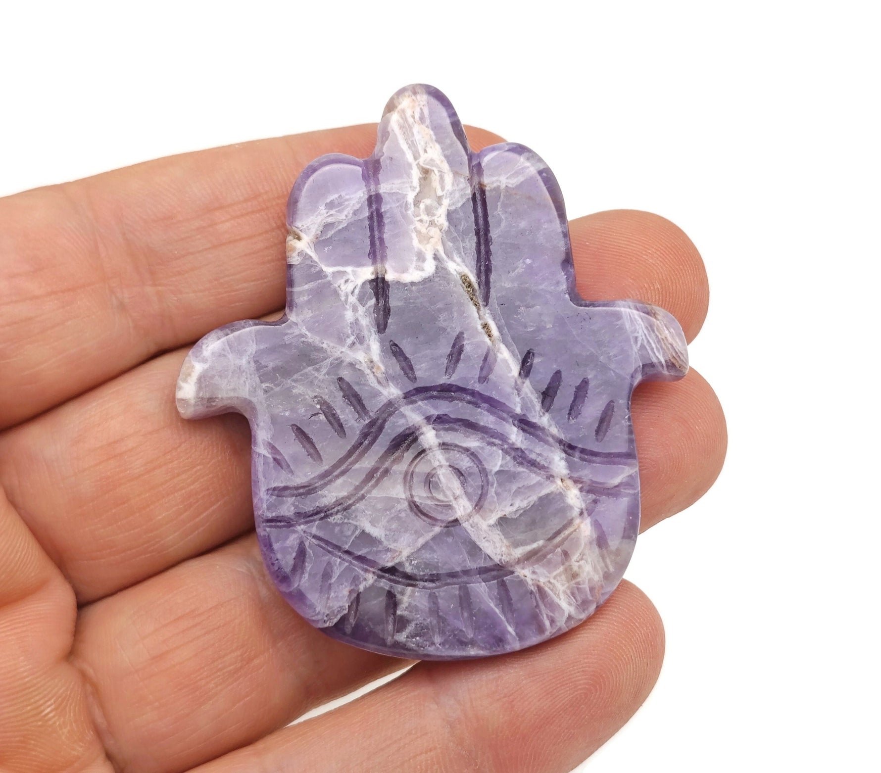 Amethyst evil eye hand gemstone carving by GemstoneGO, detailed purple amethyst with protective evil eye design.