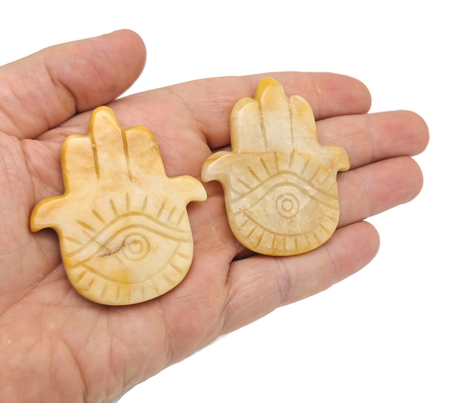 Yellow jade evil eye hand gemstone carving with intricate details, showcasing a vibrant yellow color and craftsmanship by GemstoneGO.