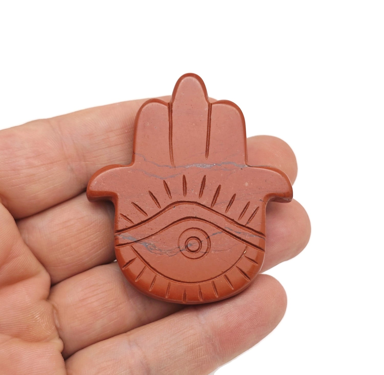 Red Jasper evil eye hand gemstone carving by GemstoneGO, showcasing detailed craftsmanship and vibrant red color.