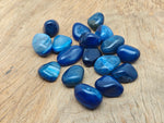 Blue Agate tumbled stone from GemstoneGO, smooth polished mineral with vibrant blue and white banding, ideal for meditation and healing.