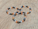 Handmade gemstone confidence bracelet with colorful beads and a silver charm, designed for positive intentions.