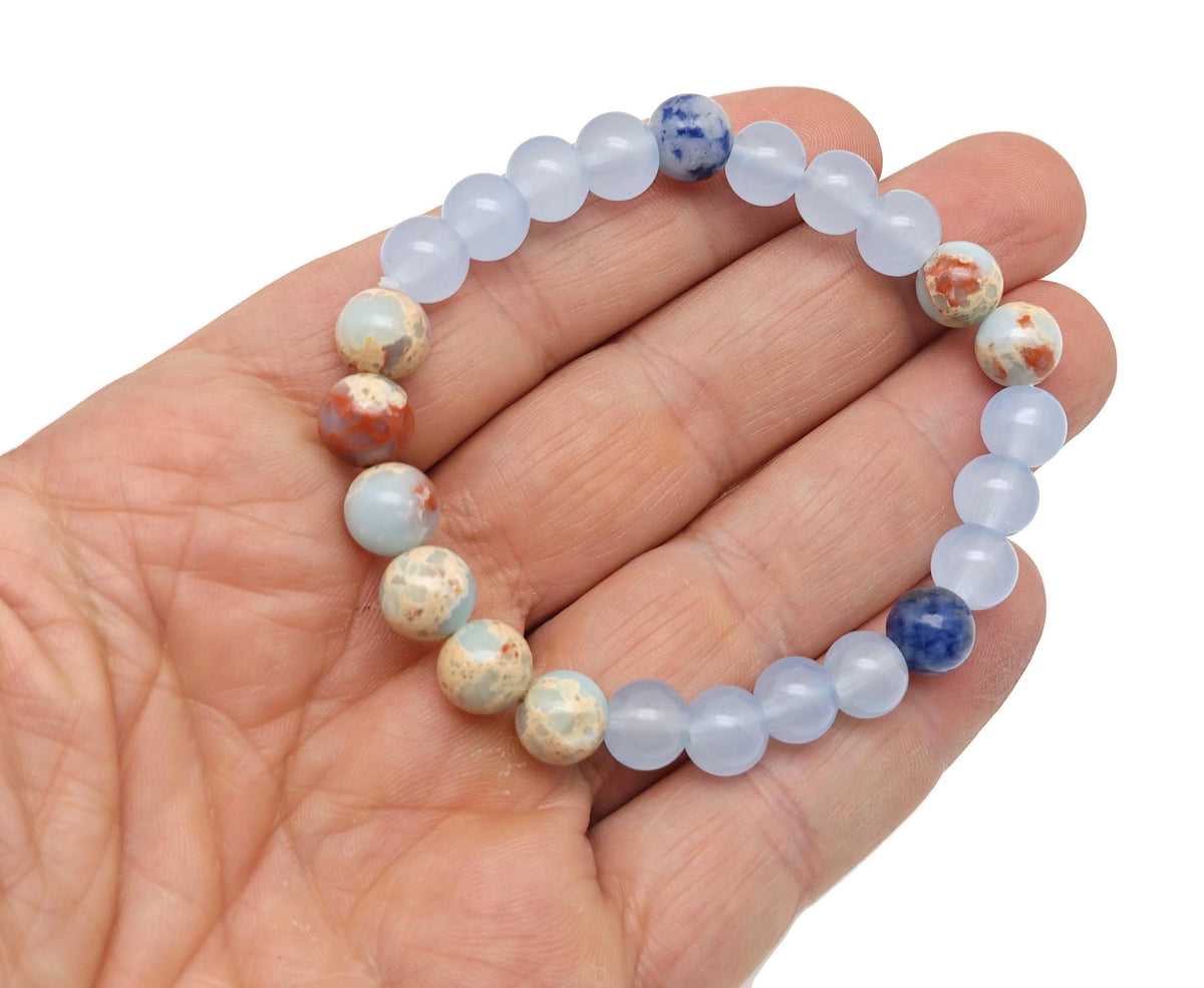 Handmade third eye chakra gemstone bracelet with blue and purple beads, featuring a silver charm, designed for intention and spiritual balance.