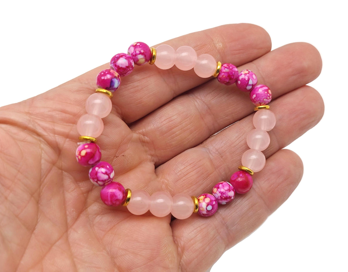 Handmade love gemstone bracelet by GemstoneGO featuring colorful beads and a heart charm on a soft fabric background.