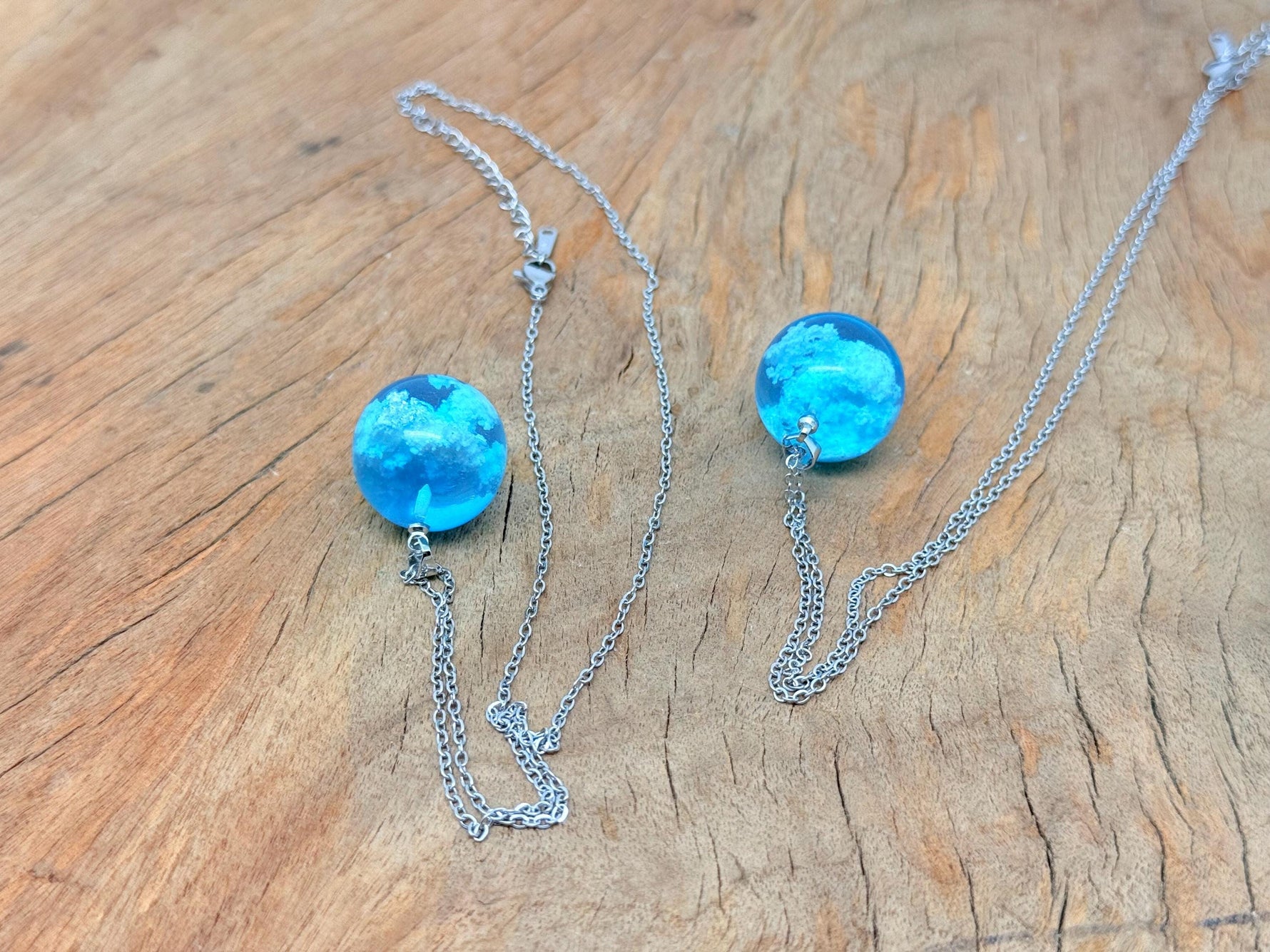 White Clouds Luminous Necklace by GemstoneGO featuring a transparent round ball pendant with blue sky and white cloud design.