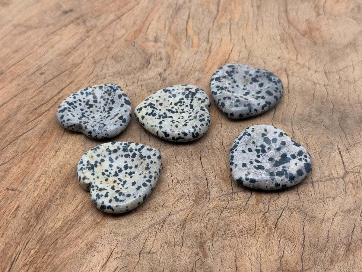 Dalmatian Jasper heart worry stone from GemstoneGO, a soothing crystal with black spots on a cream background, used for stress relief.