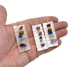 Selenite sticks pendant with chakra stones and gemstone accents, hanging from a silver chain, showcasing natural mineral textures.