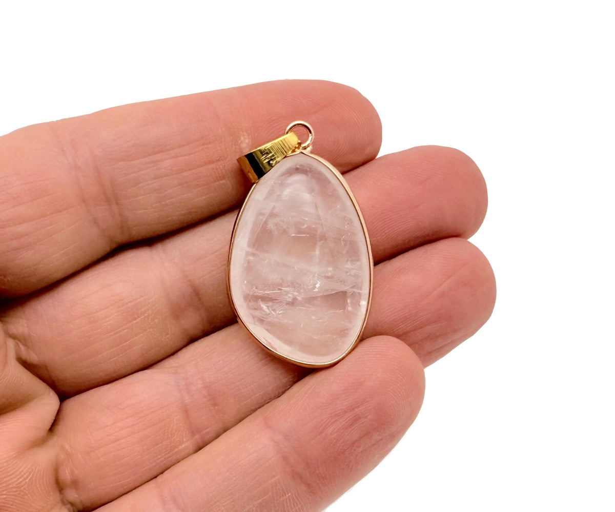 Dainty clear quartz gemstone pendant with gold setting, perfect for DIY jewelry charms, featuring a polished, transparent stone.