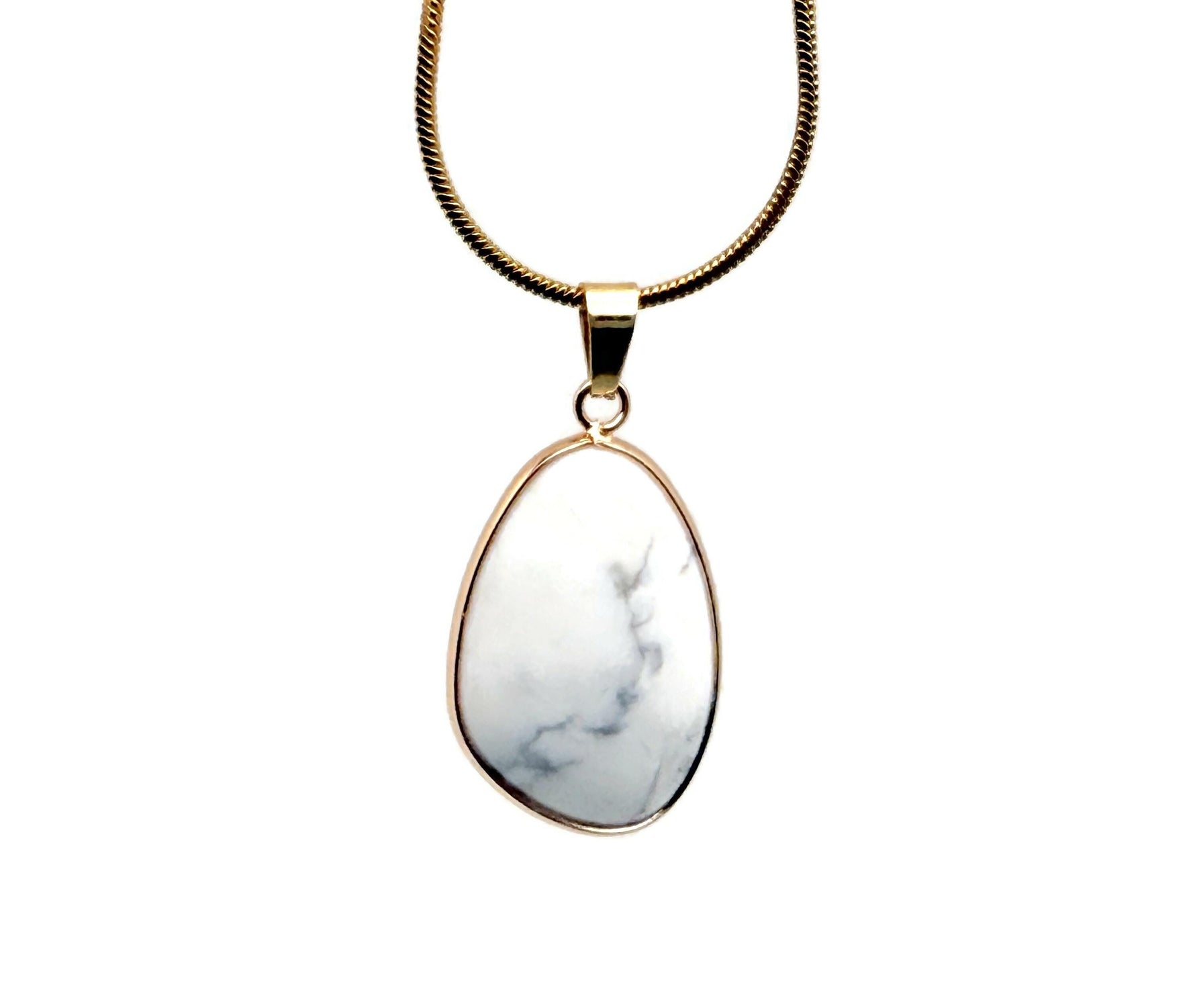 Dainty Howlite gemstone pendant with gold accents, ideal for DIY jewelry charms, showcasing a smooth, polished stone.