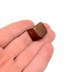Handmade 16mm carnelian cube stone from GemstoneGO, featuring carved details on vibrant orange gemstone.
