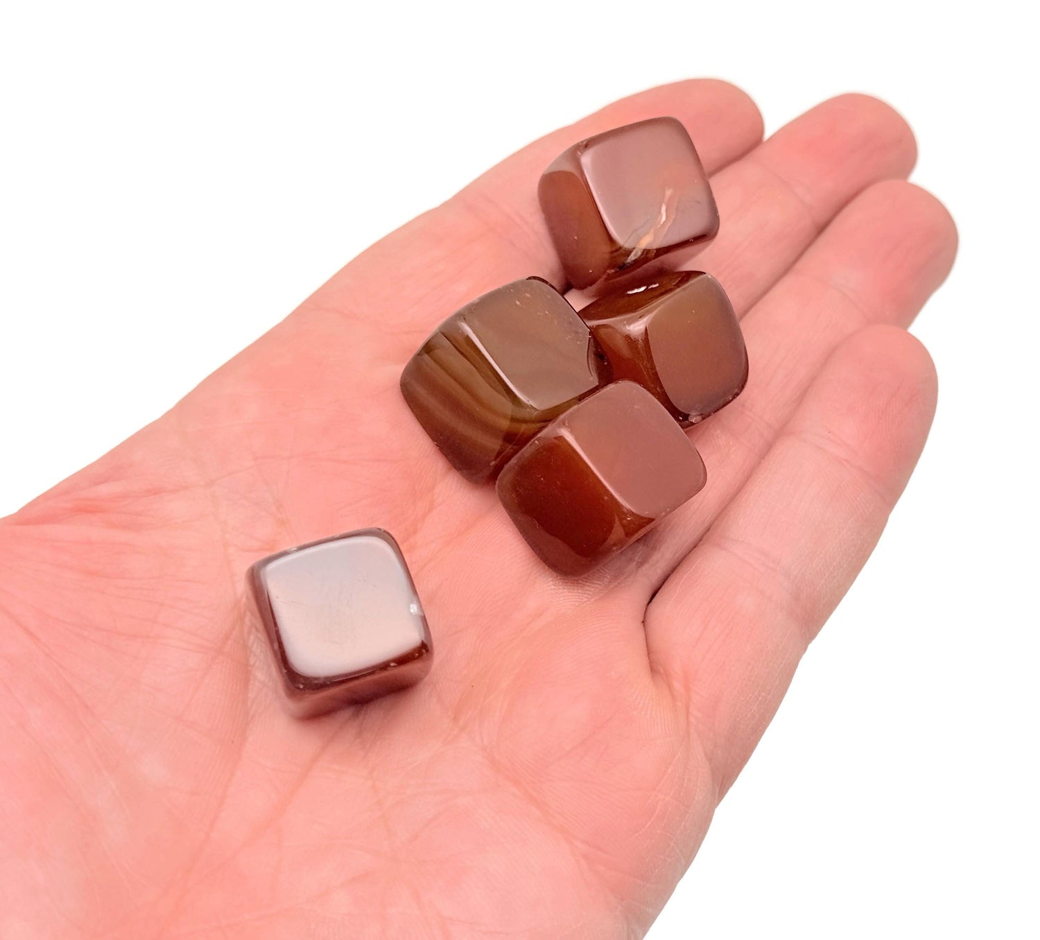 Handmade 16mm carnelian cube gemstone from GemstoneGO, showcasing its vibrant orange color and carved surface.