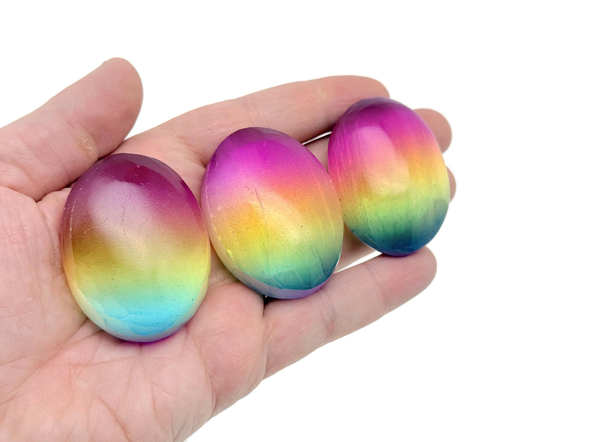 Rainbow Aura Quartz palm gemstone spa stone, 50mm, vibrant iridescent colors, smooth surface, ideal for meditation and relaxation.