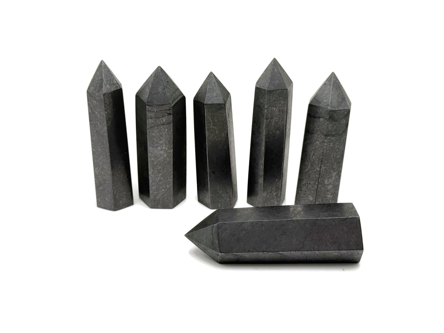 Shungite obelisk tower crystal from GemstoneGO displaying a sleek black mineral with natural texture and pointed design.
