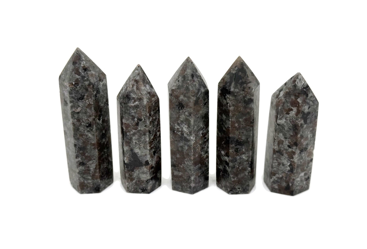 Yooperlite obelisk tower crystal featuring fluorescent sodalite stone with vibrant blue and purple hues, displayed against a neutral background.