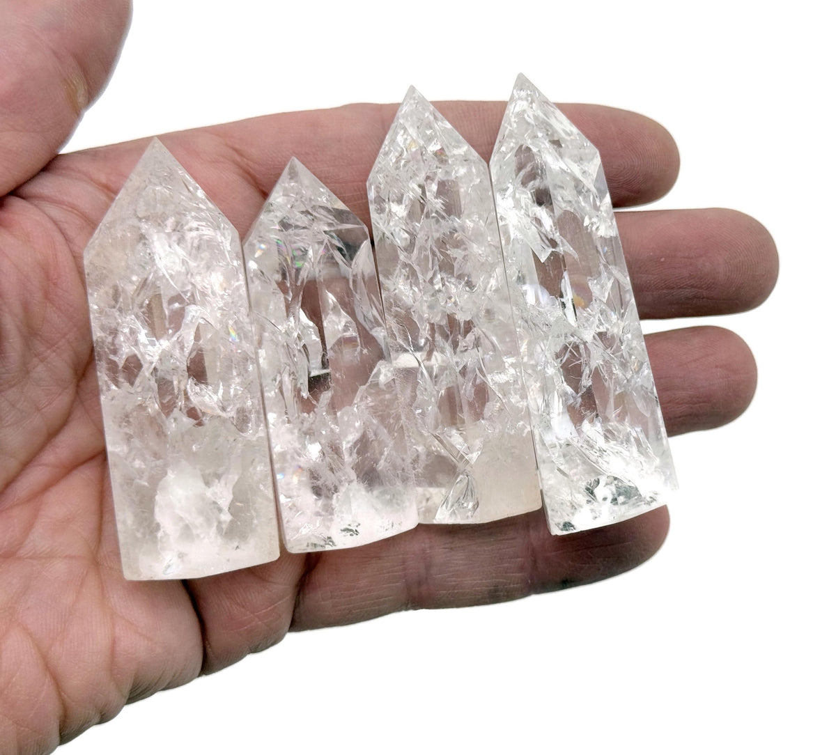 Cracked clear quartz obelisk tower crystal from GemstoneGO, showcasing a tall, pointed stone with natural internal fractures.