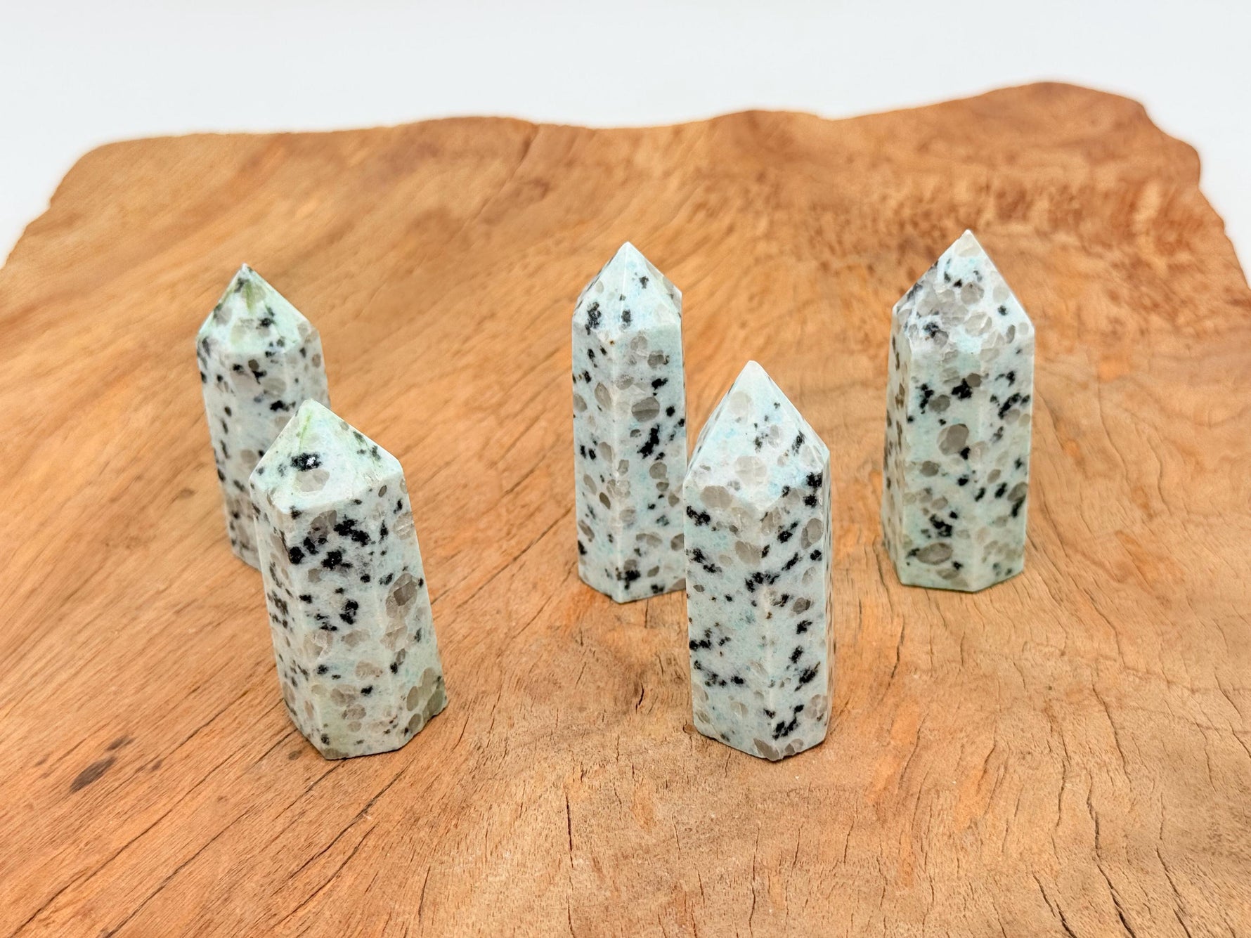 Kiwi Jasper obelisk tower crystal from GemstoneGO showing a tall, polished green and tan gemstone obelisk with natural patterning.