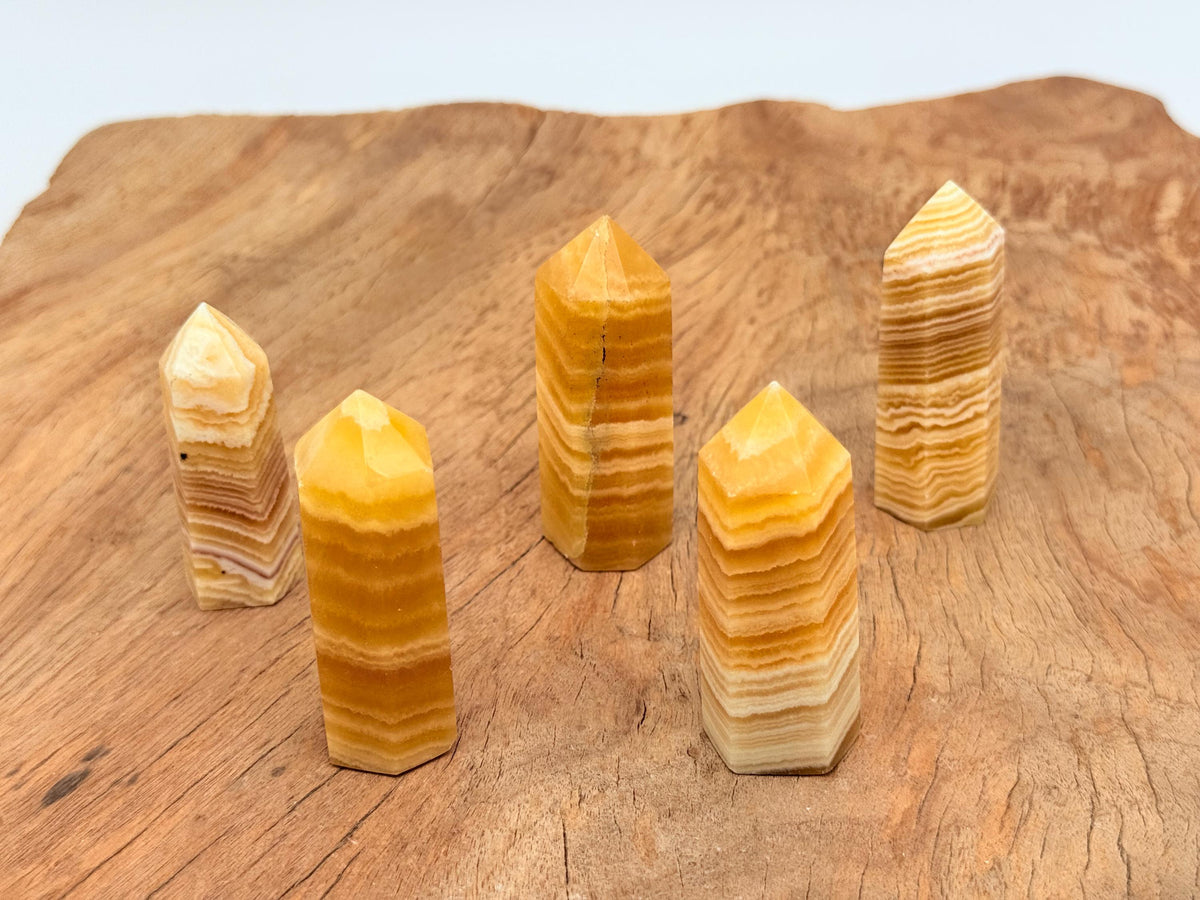 Yellow Calcite obelisk crystal tower by GemstoneGO, showcasing a vibrant yellow mineral with smooth polished surfaces and pointed tip.