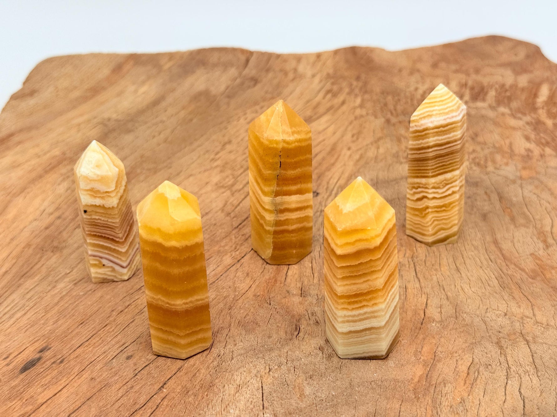Yellow Calcite obelisk crystal tower by GemstoneGO, showcasing a vibrant yellow mineral with smooth polished surfaces and pointed tip.