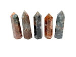 Water Grass Agate obelisk tower crystal from GemstoneGO, showing a detailed, polished green and brown banded stone sculpture.