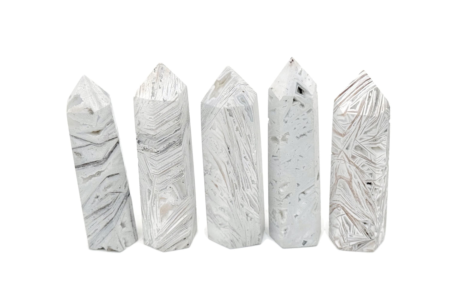 Mexican White Agate obelisk tower crystal from GemstoneGO, showcasing smooth polished white stone with natural banding details.