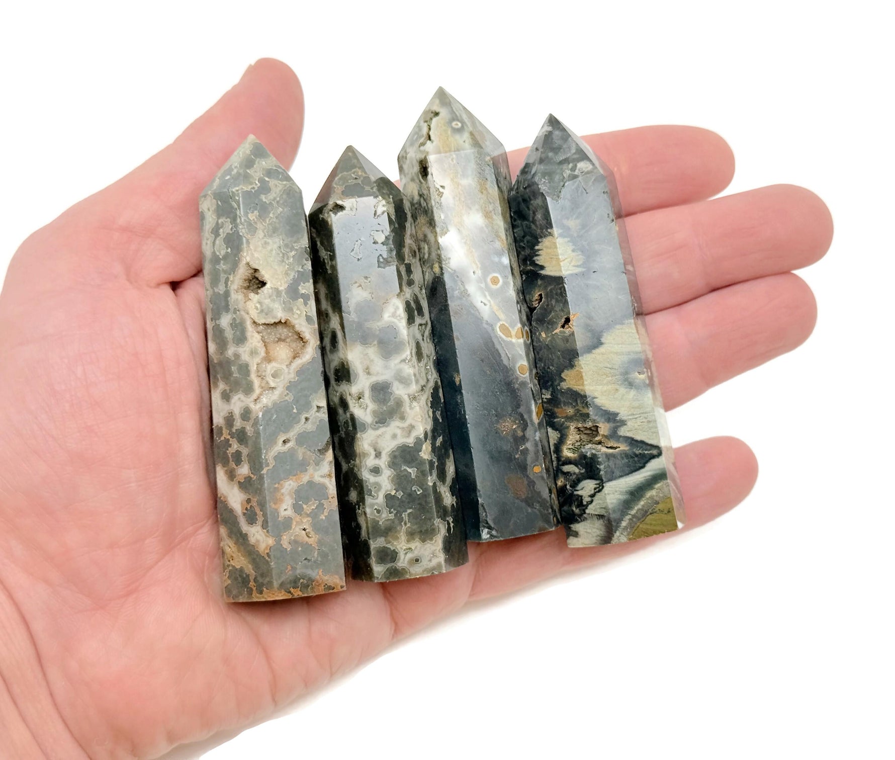 Ocean Jasper obelisk tower crystal from GemstoneGO showcasing a polished, colorful stone with natural patterns and a pointed top.