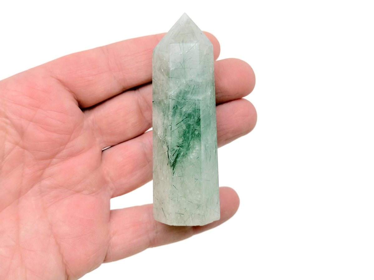 Green rutilated quartz obelisk tower crystal by GemstoneGO, showcasing a polished green quartz crystal with needle-like rutile inclusions.