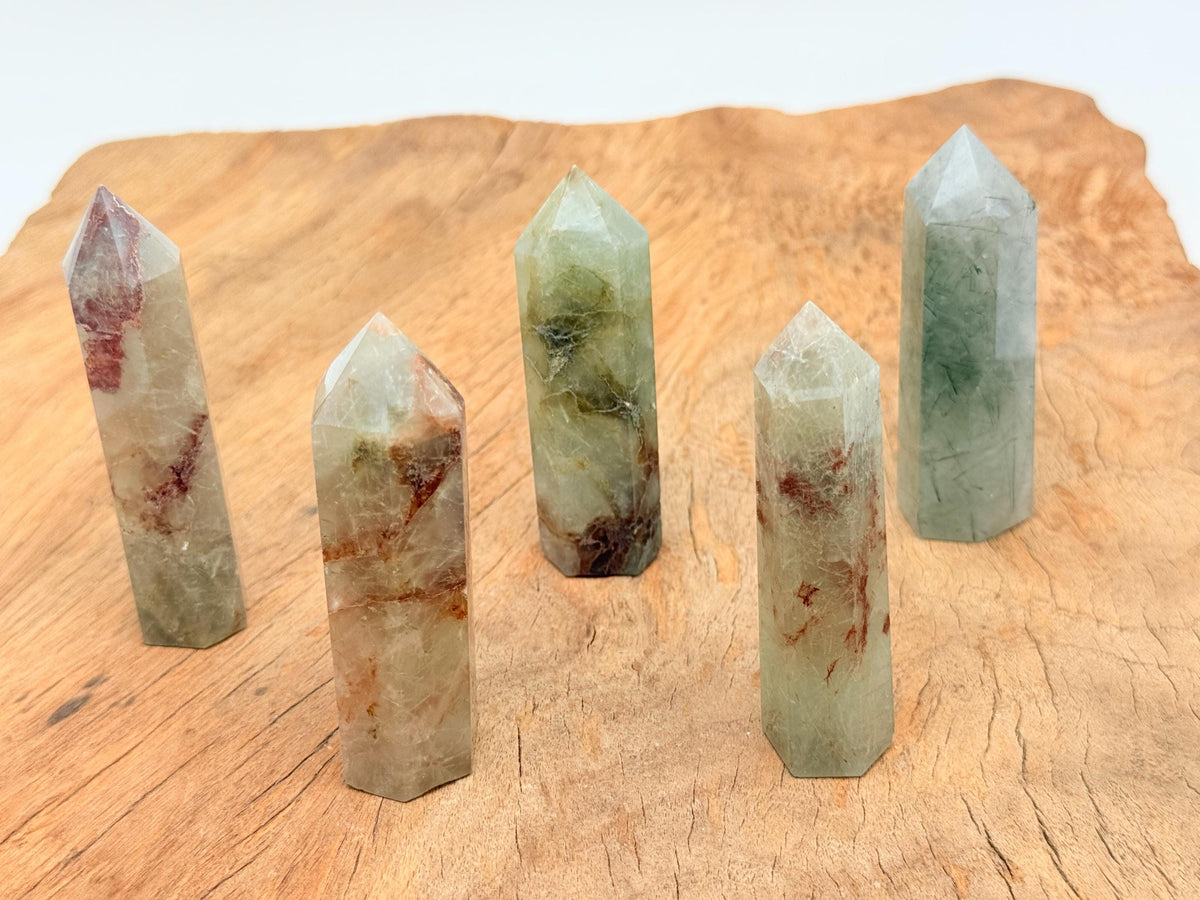 Green rutilated quartz obelisk tower crystal from GemstoneGO with natural mineral inclusions and a polished pointed shape.