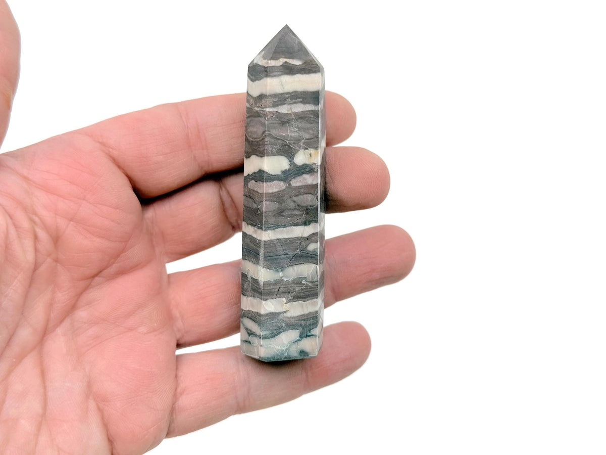 Red Zebra Calcite obelisk tower crystal by GemstoneGO, showcasing vibrant red and white striped mineral with a polished finish.