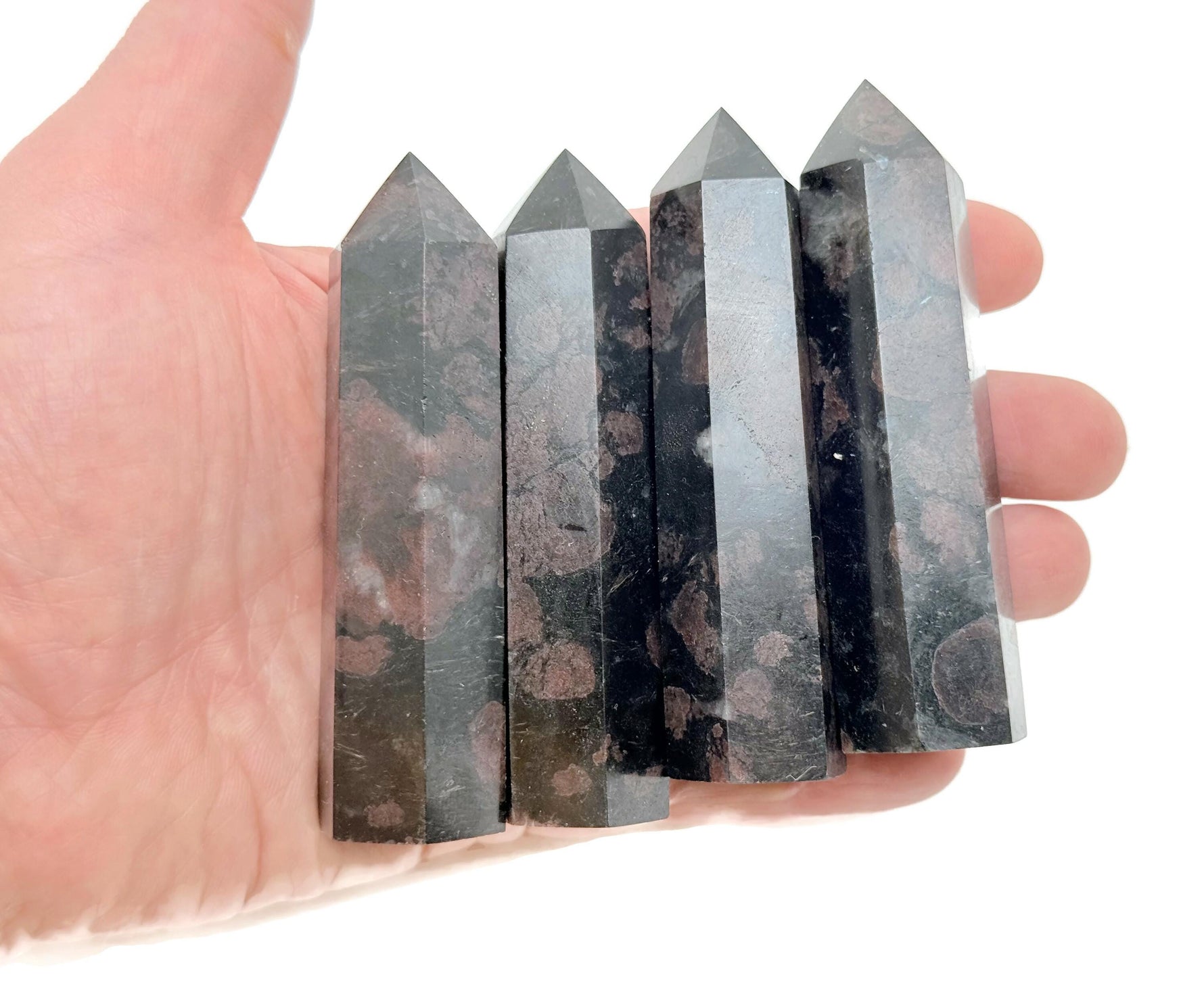 Garnet obelisk tower crystal from GemstoneGO, showing a deep red gemstone carved into a tall, pointed obelisk shape.