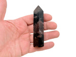 Garnet obelisk tower crystal from GemstoneGO, featuring a polished deep red gemstone with pointed geometric shape.