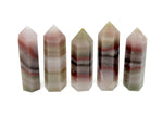 Pink banded calcite obelisk tower crystal from GemstoneGO, showcasing a smooth, polished pink and white striped stone with a pointed tip.