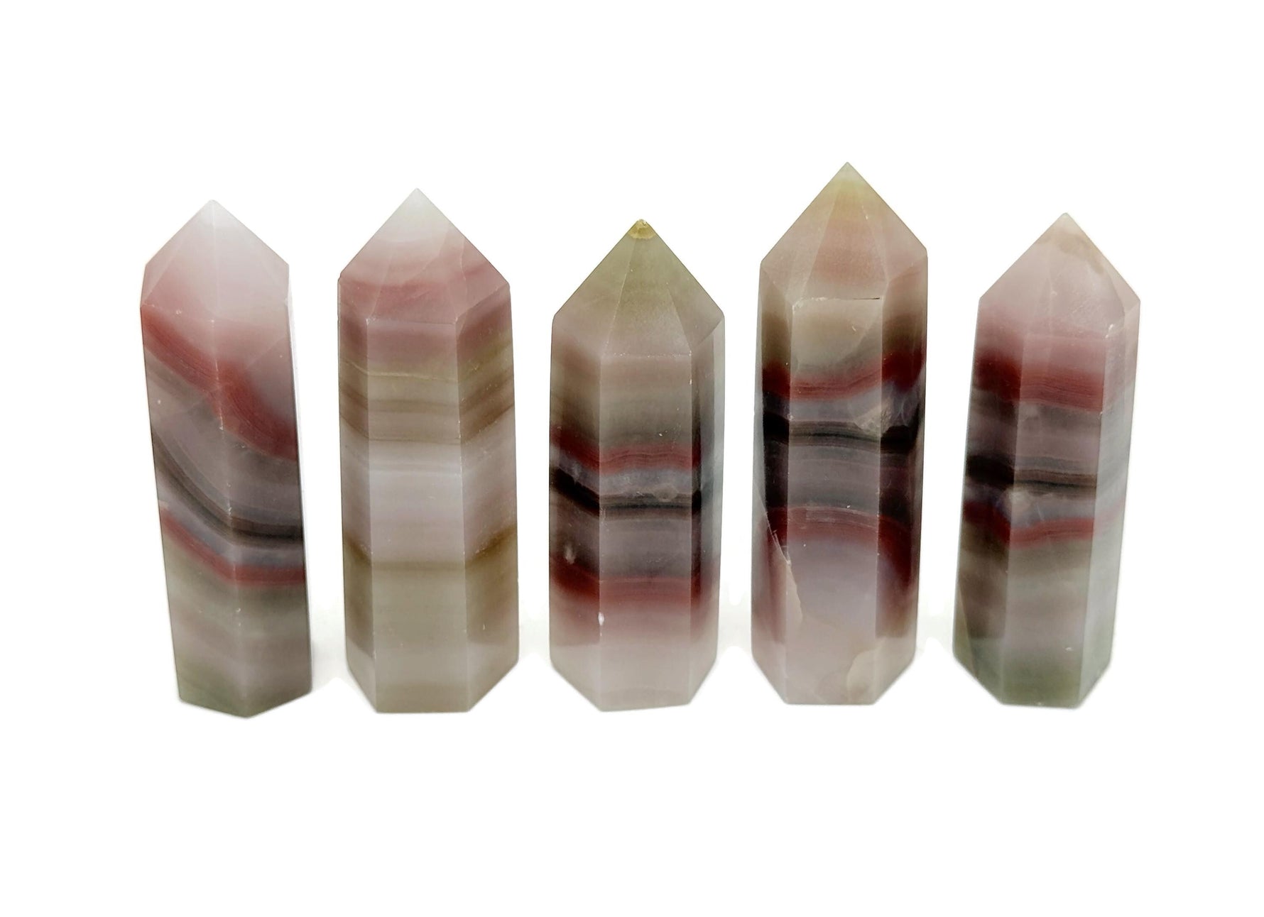 Pink banded calcite obelisk tower crystal from GemstoneGO, showcasing a smooth, polished pink and white striped stone with a pointed tip.