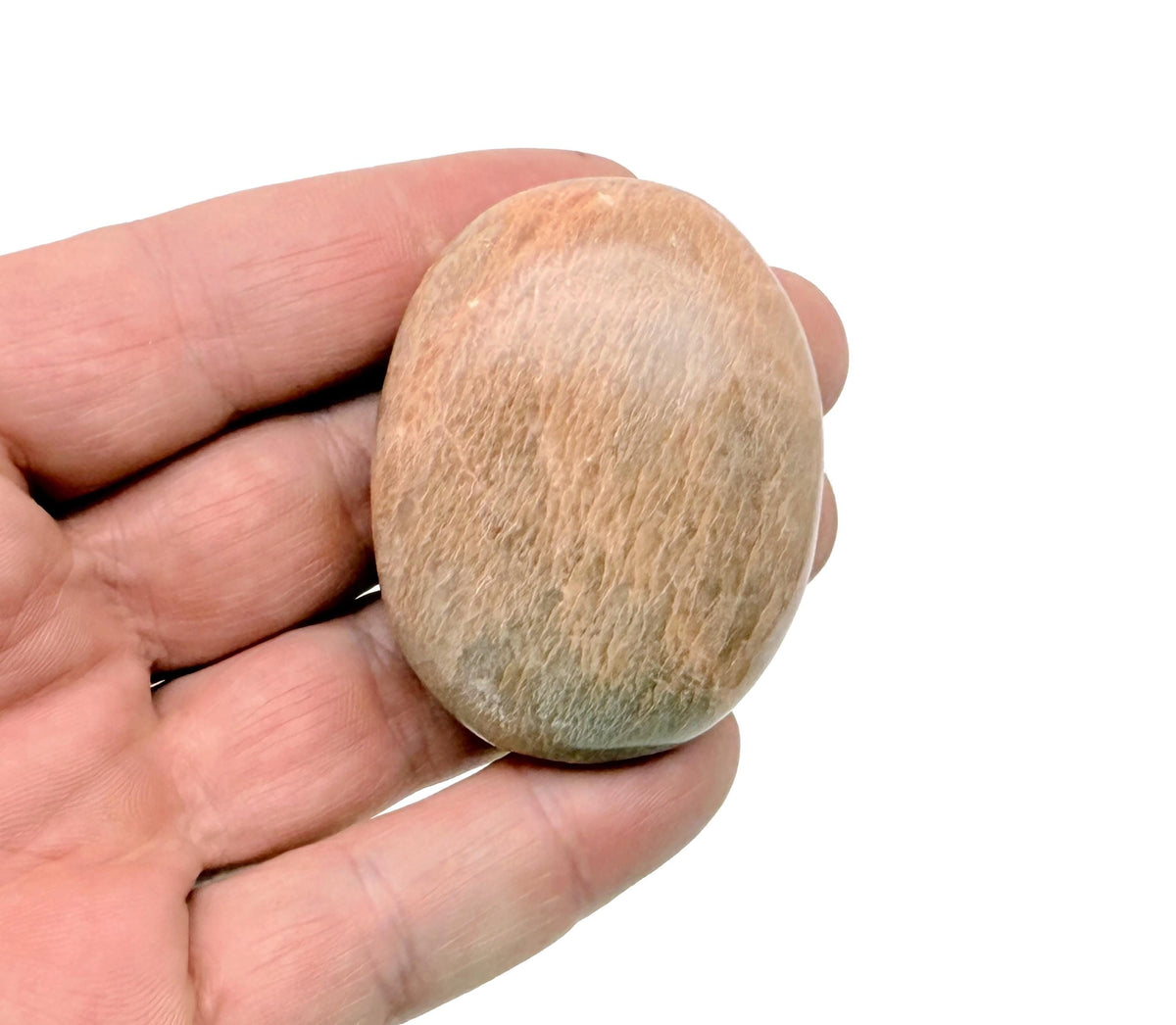 Polished peach moonstone palm gemstone spa stone from GemstoneGO, smooth and rounded for massage and relaxation.