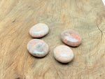 Peach moonstone palm gemstone spa stone from GemstoneGO, smooth oval-shaped healing crystal for relaxation and meditation.