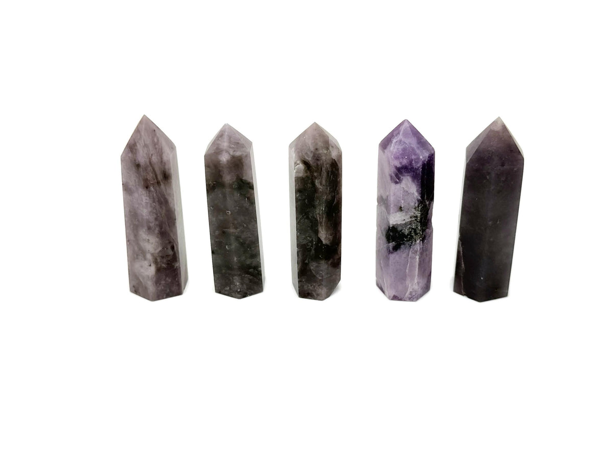 Lepidolite obelisk tower crystal from GemstoneGO, showcasing purple and pink hues with smooth polished surfaces and natural mineral patterns.